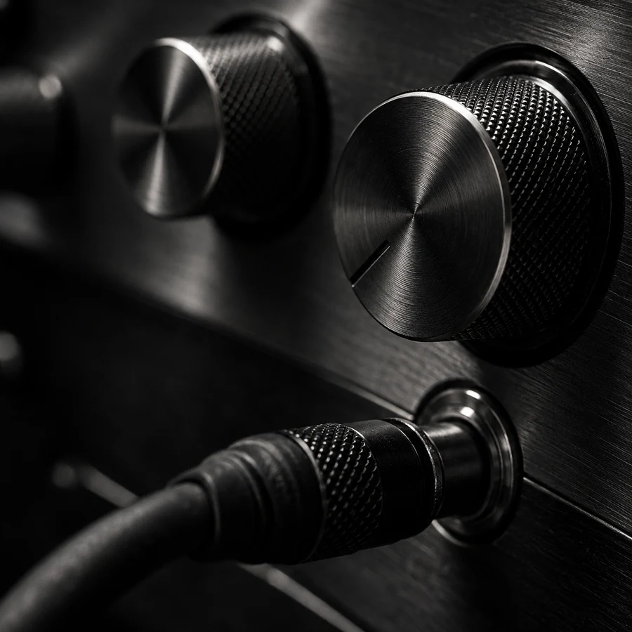 Close detail of analogue audio knobs and a cable connection